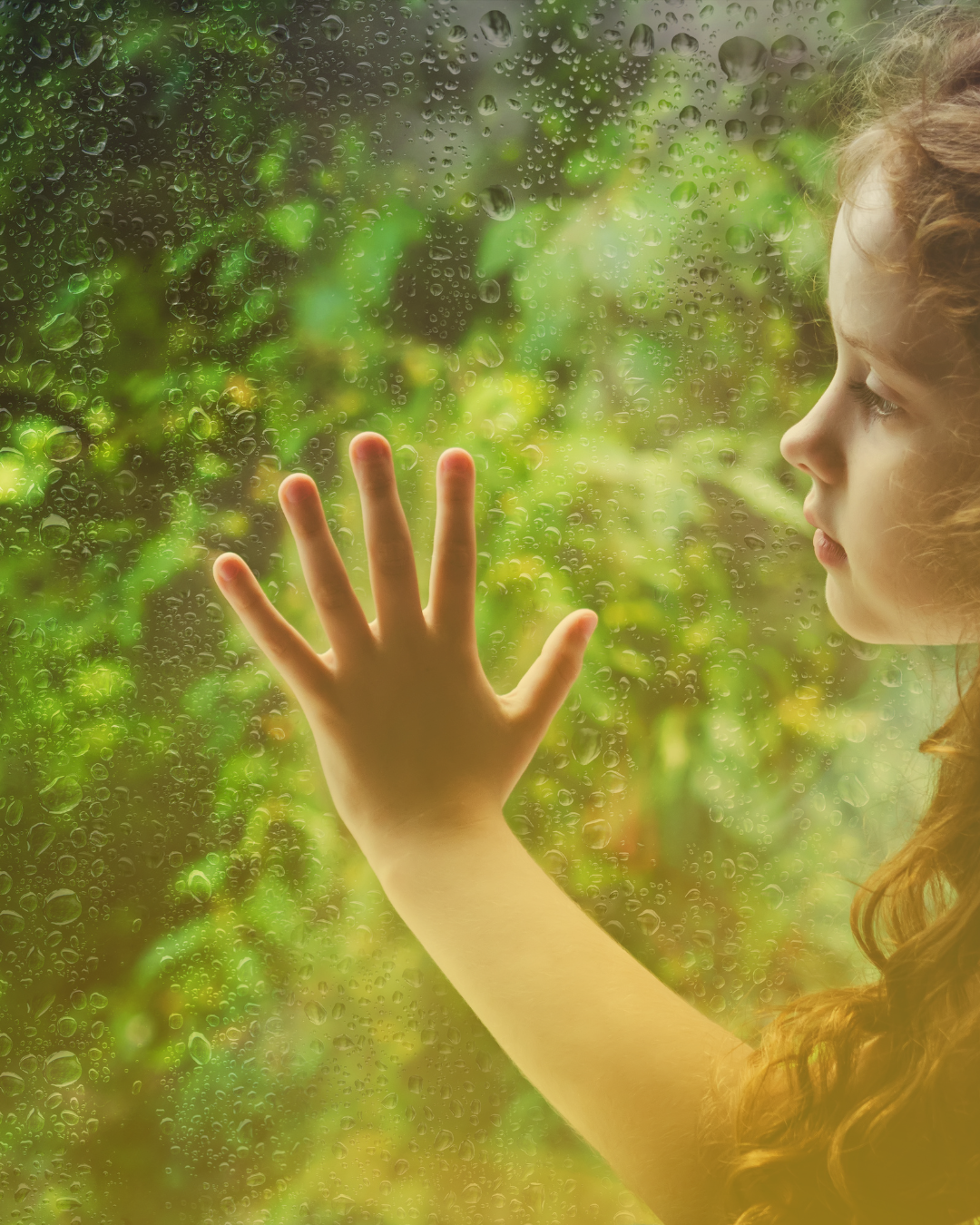 Child's hand pressed against a rain-streaked window